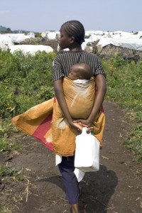 A woman and a baby walk back to a camp for displaced people in Democratic Republic of Congo.